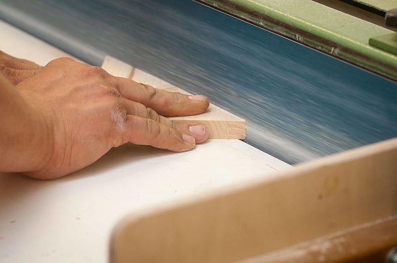 Blick auf die Hand während Holzarbeiten in einer Tischlerei.