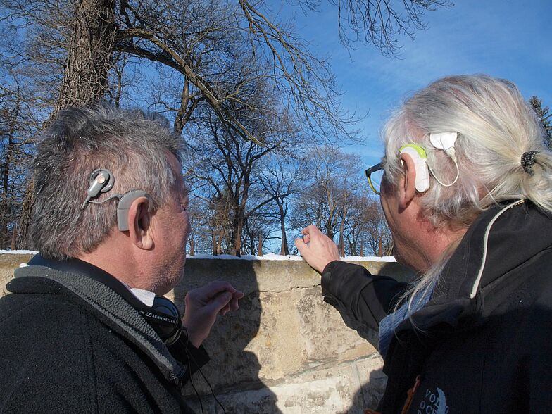 Zwei Menschen mit einem Cochlea Implantat mit Blick in die Natur.