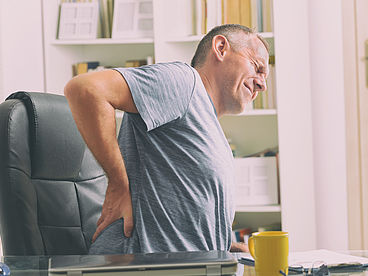 Einseitige körperliche Belastung, ein bewegungsarmer Lebensstil, Übergewicht und Leistungssport sind die meistverbreiteten Gründe für Rückenschmerzen.