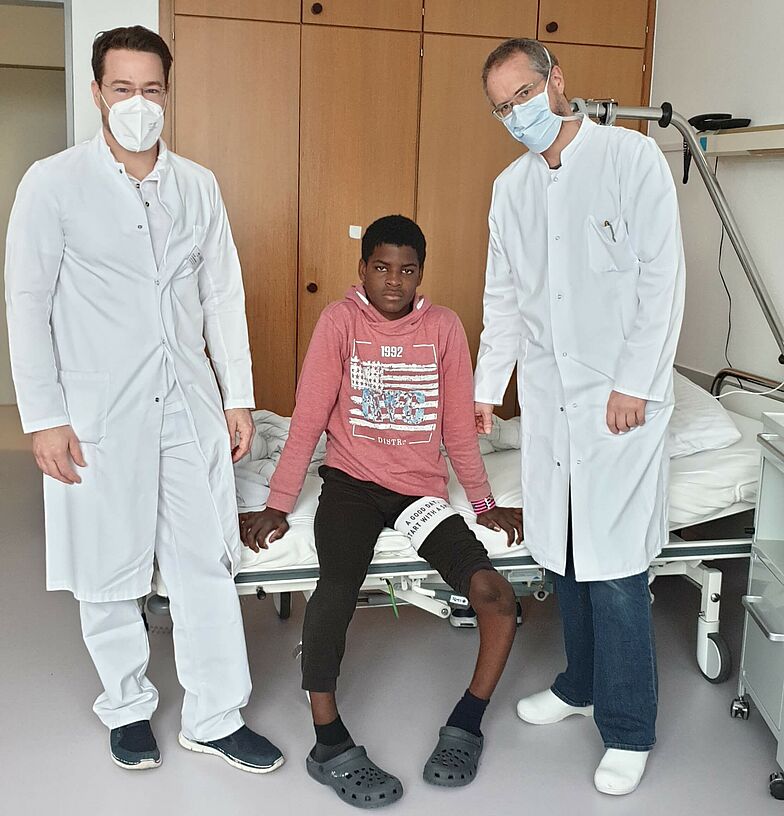Patient mit zwei Ärzten im Patientenzimmer
